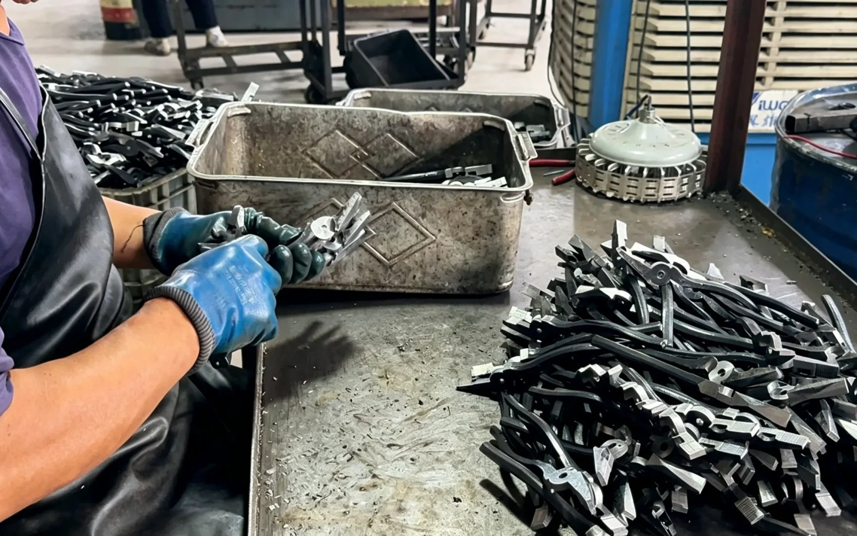 www.huashutools.com Huashu Tools worker assembling semi‑finished pliers, hand‑tool assembly station in hardware factory